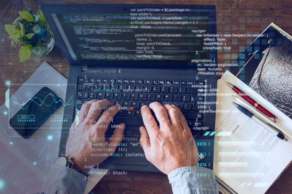 Man's hands write code on a laptop keyboard